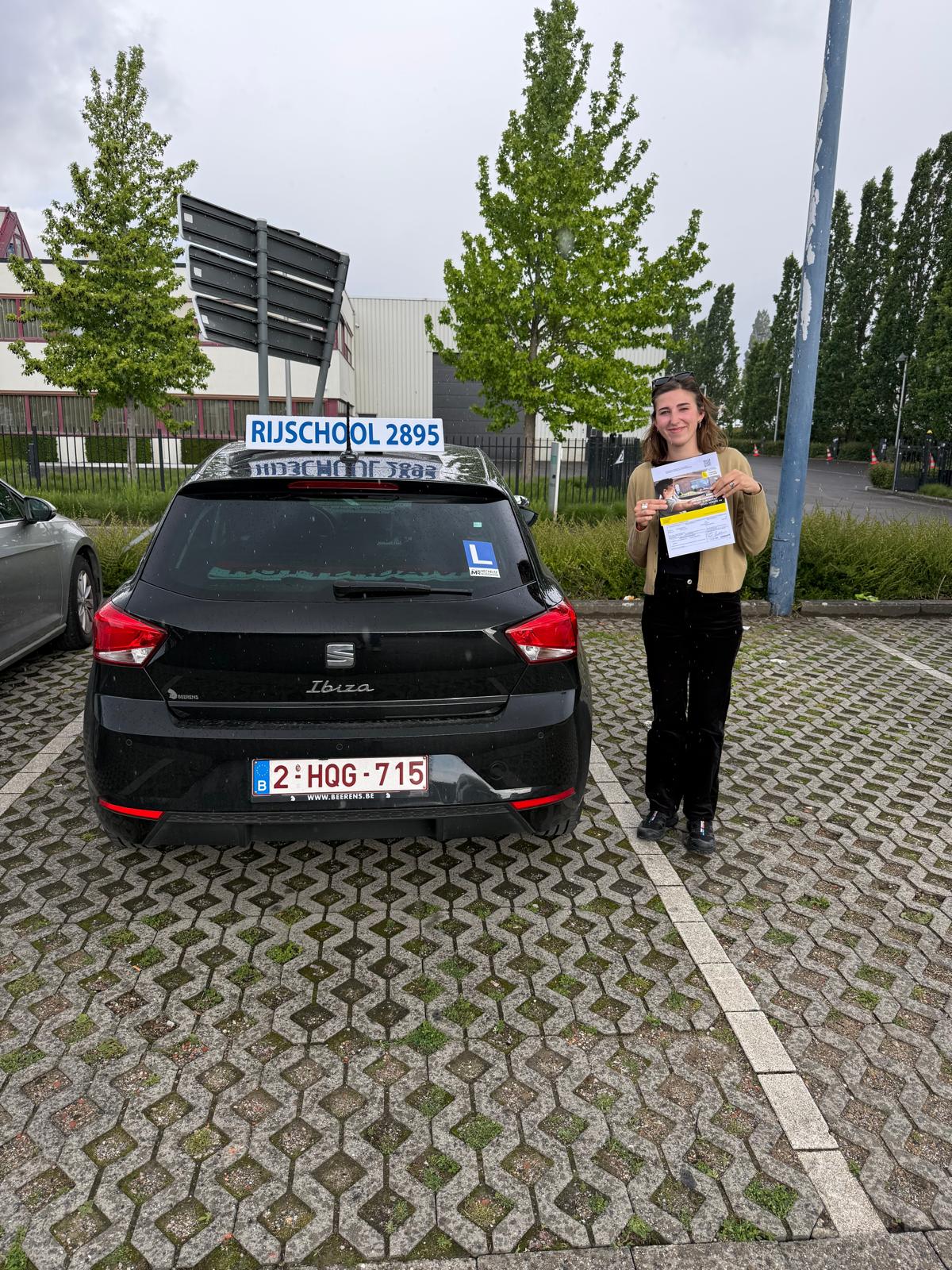 Geslaagde leerling in een beige vest met haar resultaat