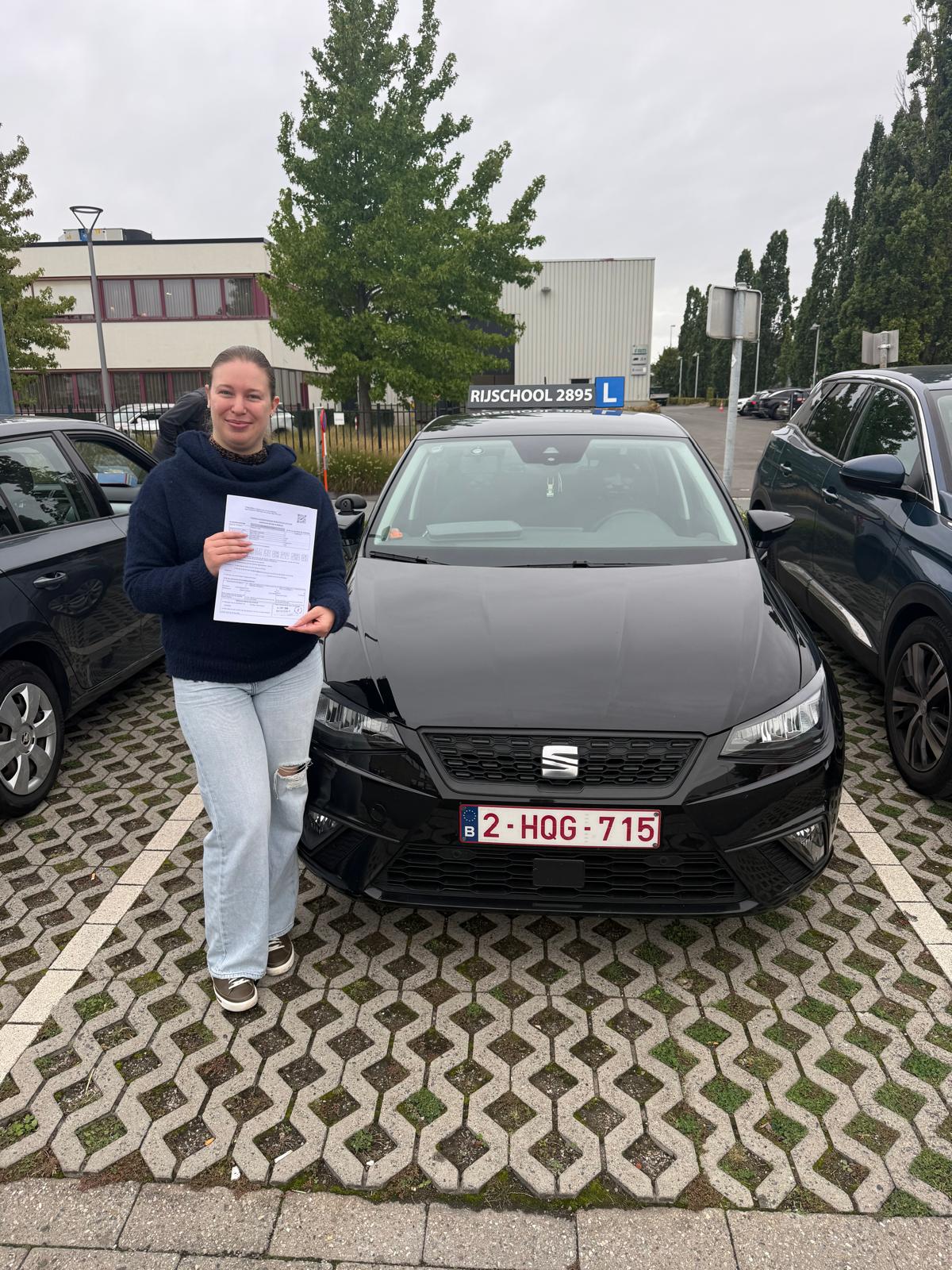 Leerling met haar resultaat voor de zwarte lesauto