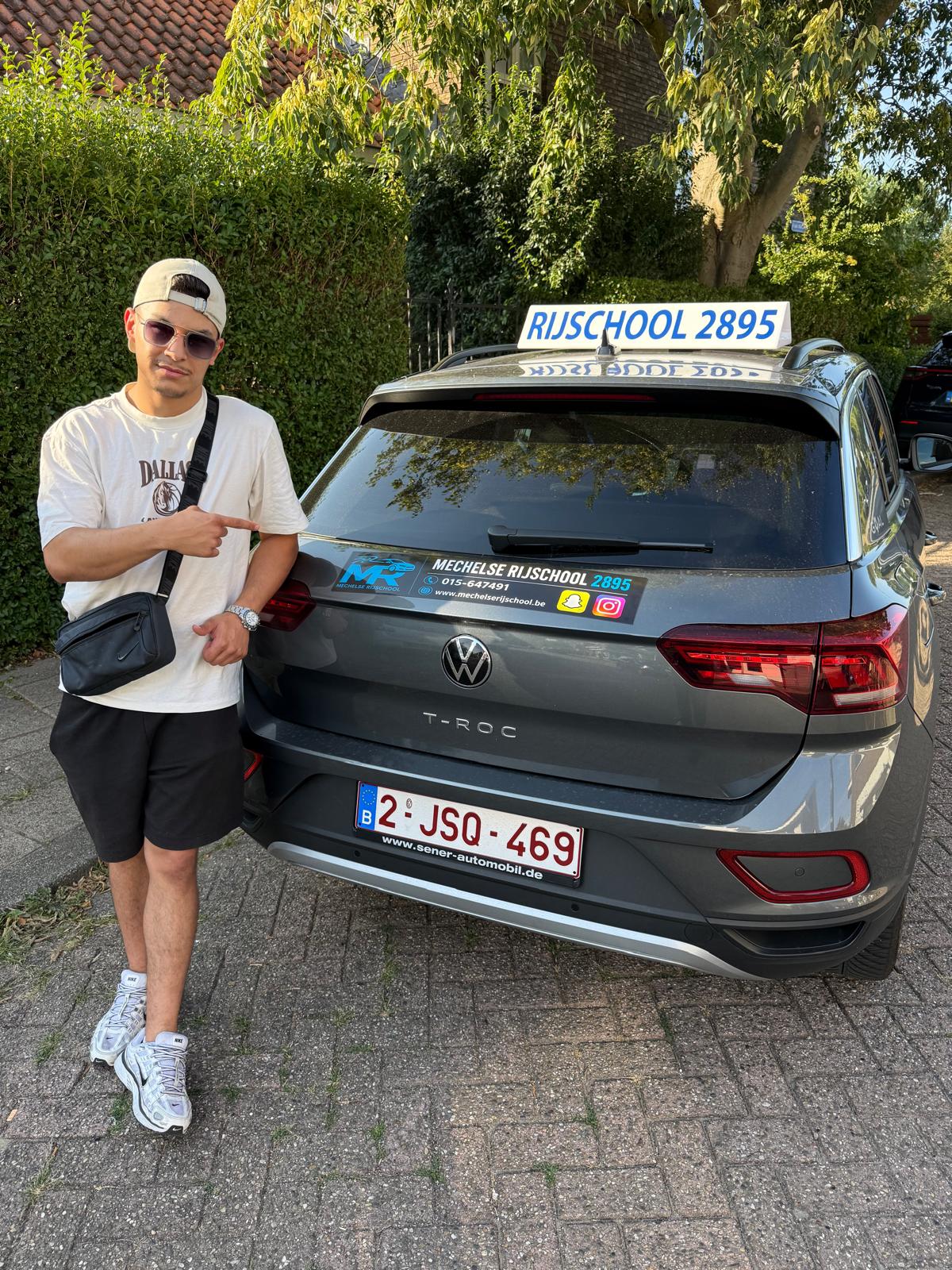 Geslaagde leerling naast de grijze Volkswagen T-Roc